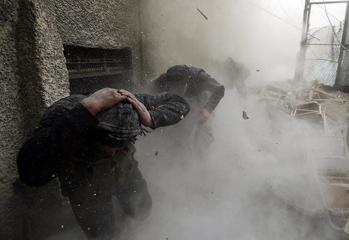 20 Photos: Free Syrian Army fighters run for cover as a tank shell explodes