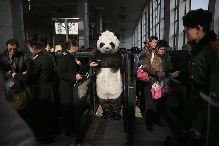 20 Photos: a woman wearing a panda costume has her ticket checked in Beijing