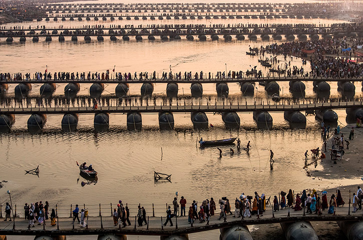 Maha Kumbh : Hindu pilgrims make their way over pontoon bridges near Sangam