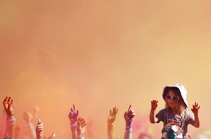 24 hours in pictures: A girl cheers after crossing the finish line of the Colour Run at Sydney