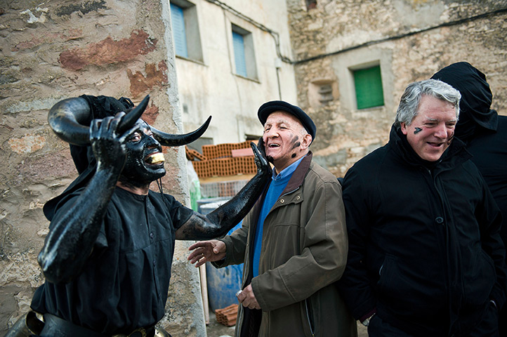 24 hours in pictures: A costumed man covered in oil and soot carnival celebrations in spain