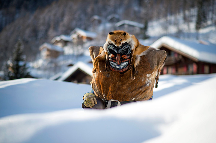 24 hours in pictures: A 'Tschaeggaettae', a masked participant of  traditional carnival cortege