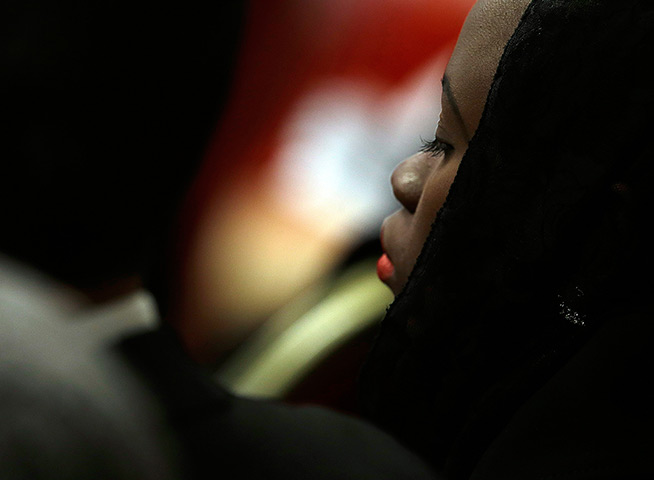 24 hours in pictures: A faithful attends a mass, celebrated by Cardinal Tarcisio Bertone
