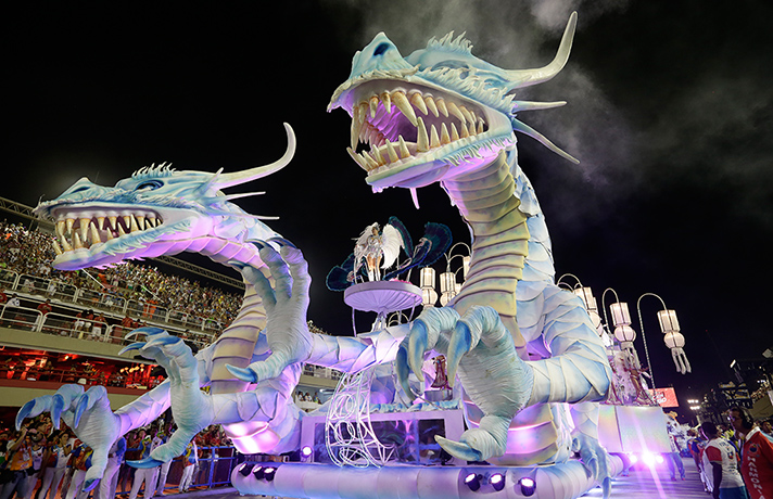 Rio Carnival 2013: dancers stand on a dragon float during Inocentes de Belford Roxo parade