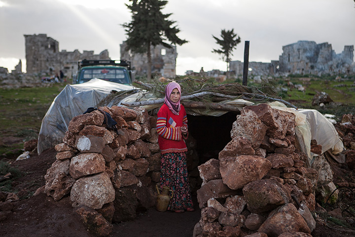 24 hours: Serjilla, Syria: A girl stands at the entrance of a makeshift home