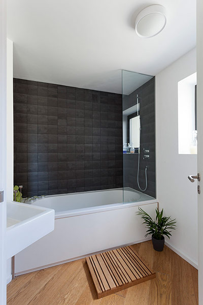 Homes - Lewisham NB: bathroom with wooden floor and grey tiled wall