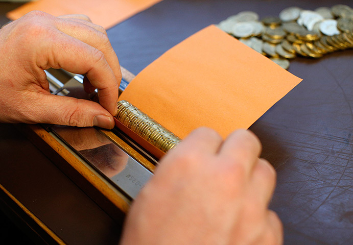 Germany's smallest bank: CEO Peter Breiter rolls euro coins in paper