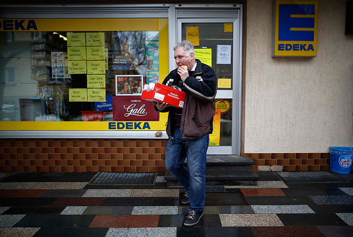 Germany's smallest bank: Peter Breiter bites into his lunchtime snack as he leaves a corner shop 