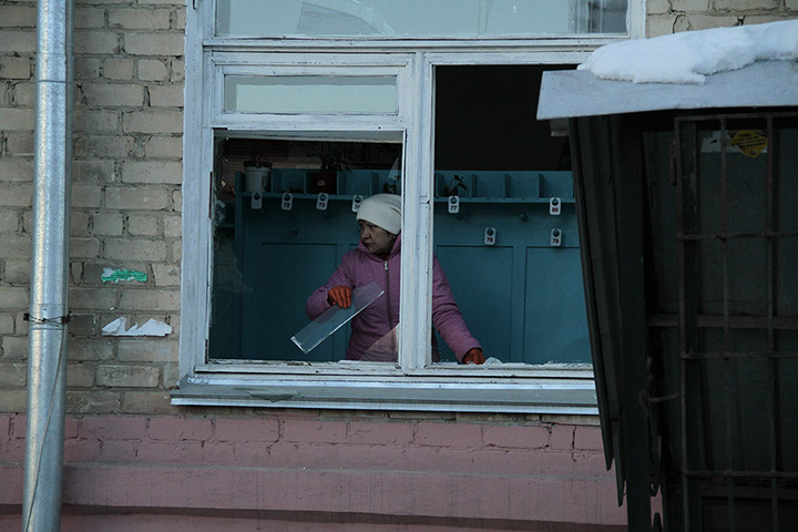 meteorites in Russia: A woman removes broken glass from a window frame in Chelyabinsk 