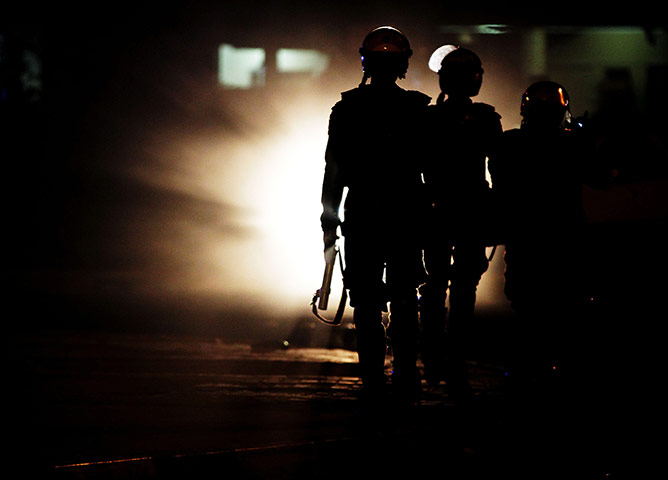 24 Hours:  Riot police officers patrol during clashes with protestors in Bahrain