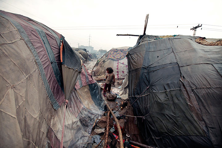 24 Hours: A girl stands among makeshift tents in Islamabad, Pakistan