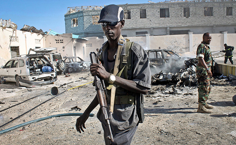 24 hours: Mogadishu, Somalia: Somali soldiers walk near the wreckage