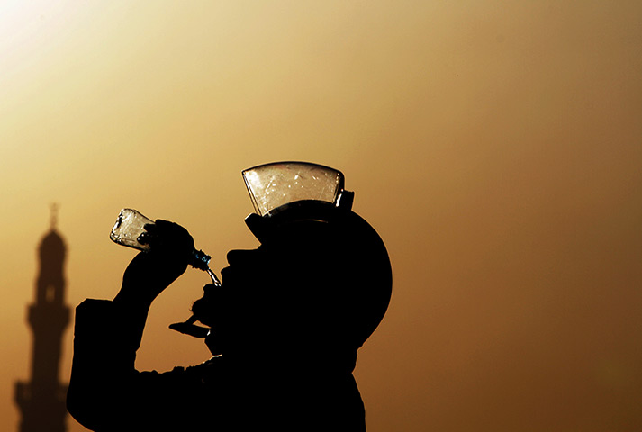 24 hours: Daih, Bahrain: A riot policeman drinks water 