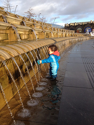 Your Pictures - Flow: toddler in blue jumpsuit touching water fountain