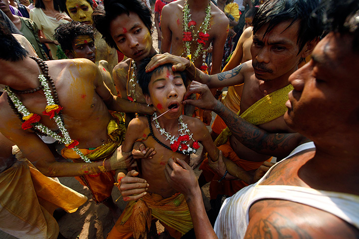 24 hours: Rangoon, Burma: A Hindu devotee pierces a Hindu boy's mouth
