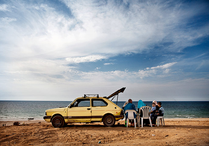 Big Pic - Tanya Habjouqa: middle eastern family on a beach with yellow car