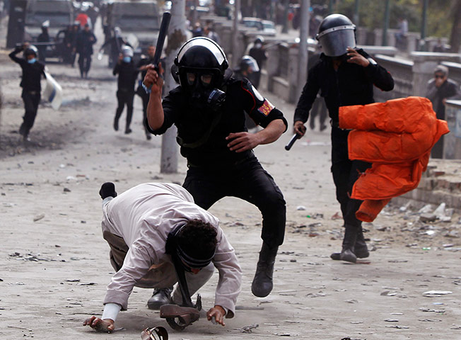20 Photos: Riot policemen beat a protester opposing Egyptian President Mohamed Mursi