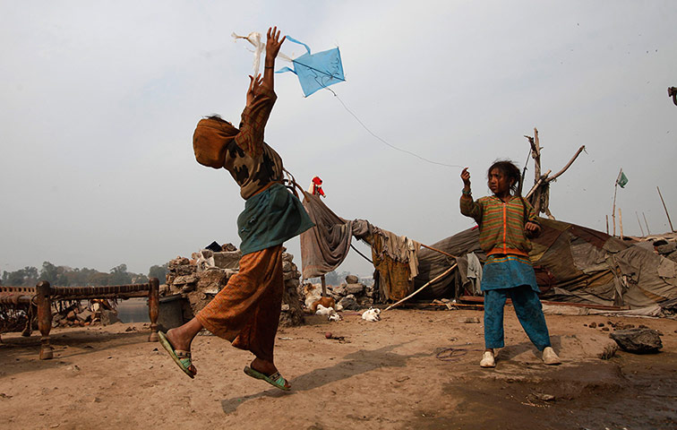 24 hours: Girls try to fly their kite on the outskirts of Lahore
