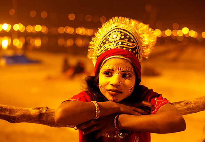 24 hours: A child dressed as Hindu goddess Parvaty, watches a religious procession