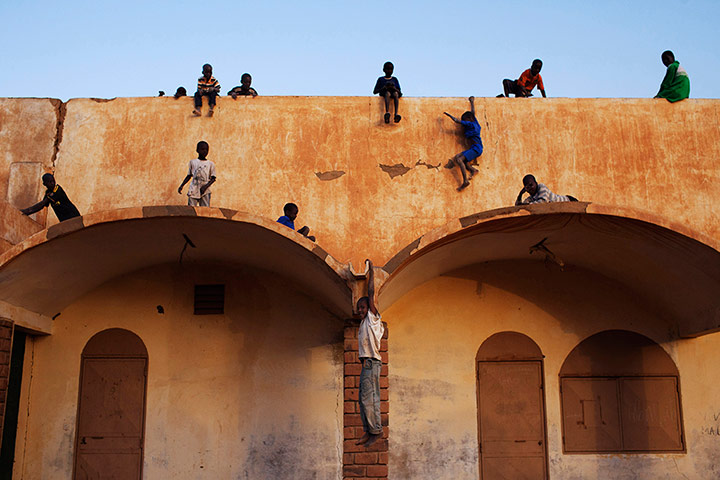 20 Photos: Boys play on the roof of the entrance to a football stadium in Gao