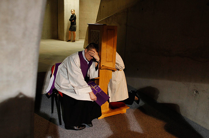 20 Photos: A priest listens to a confession during Mass in Warsaw