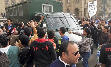 Egyptian protesters attack a police vehicle during a demonstration in Cairo