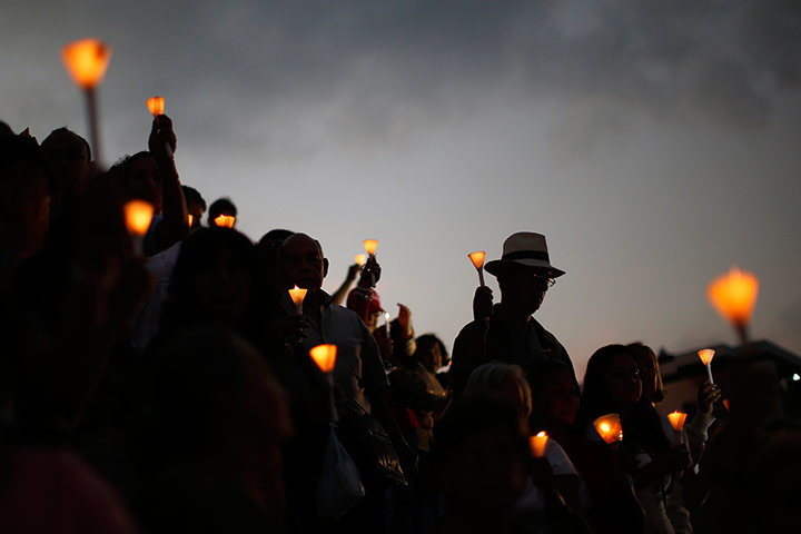 24 hours:  People hold candles during a praying ceremony 