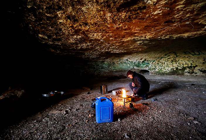 24 hours: Jabal al-Zaweya, Syria: A Free Syrian Army fighter prepares a fire