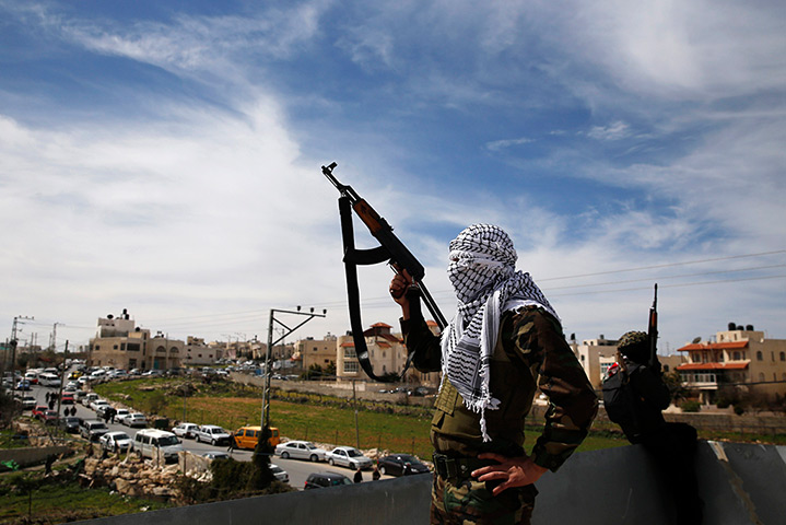 24 hours: Sa'ir, West Bank: Masked Palestinian gunmen hold weapons