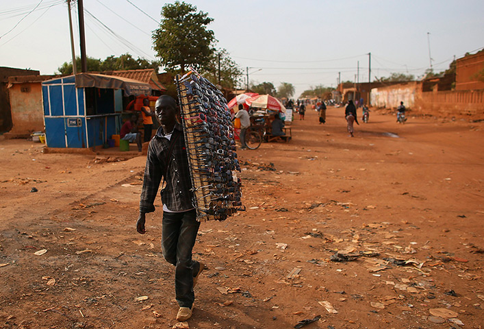 FTA: Nic Bothma: A sunglasses salesman walks down a street in Ouagadougou 
