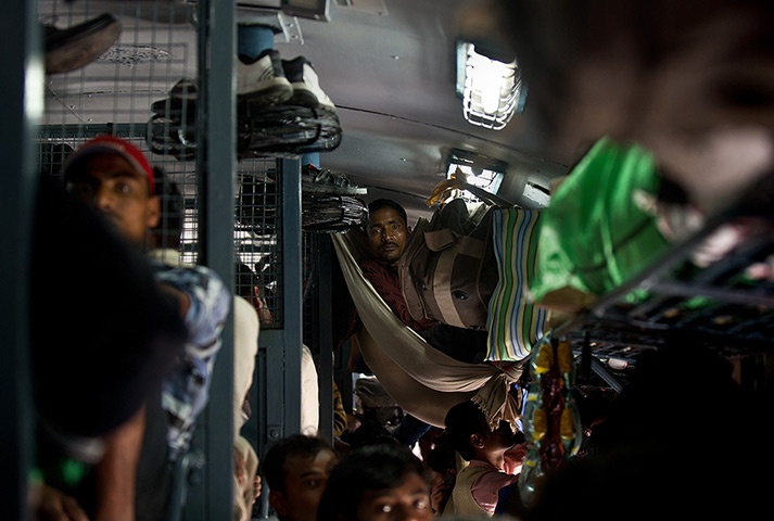 24hours in pictures: An Indian man travels in a crowded coach on a train 