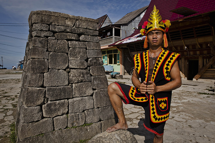 Stone jumping on Nias: A villager poses by a stone tower in Bawomataluwo