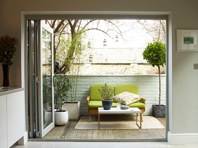 Homes - Economy Class: shot of outside terrace with green sofa 