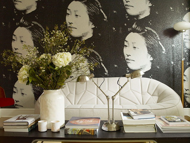 Homes - Economy Class: cream chair with wallpaper of faces 