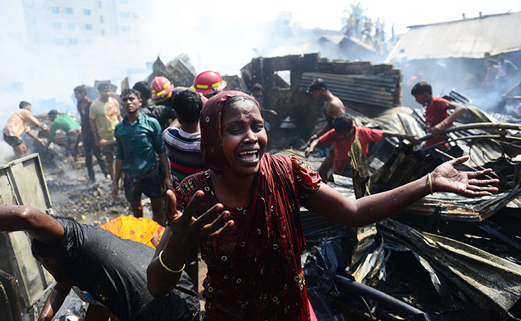 24 hours: Dhaka, Bangladesh: a resident cries in front of the ashes of a slum