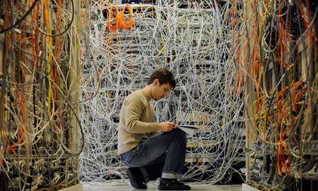 An engineer sitting in a tangle of wires