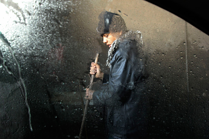 24 hours in pictures: A boy works at a car wash in Aleppo