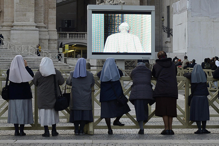 The Pope's last day: A group of nuns watch a screen in St Peter's square