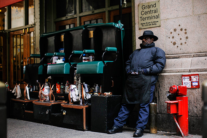 24 hours: New York, US: A man waits for customers to shine shoes
