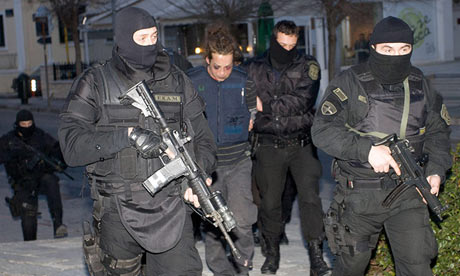 Greek police escort one of the suspected bank robbers after their arrest
