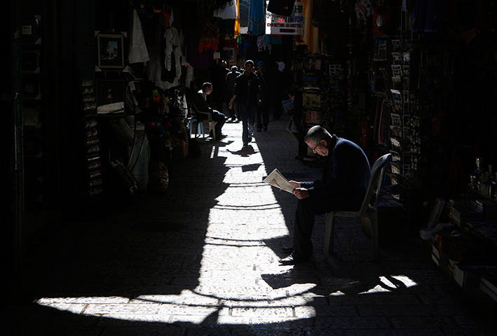 24 hours: Jerusalem: A shop vendor reads a newspaper at a market in the Old City 