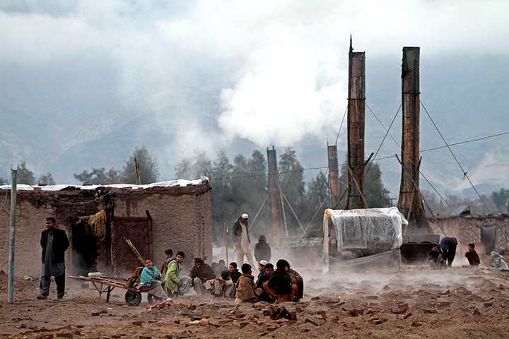 24 hours: Jalalabad, Afghanistan: Boys warm their hands over a brick factory fire 