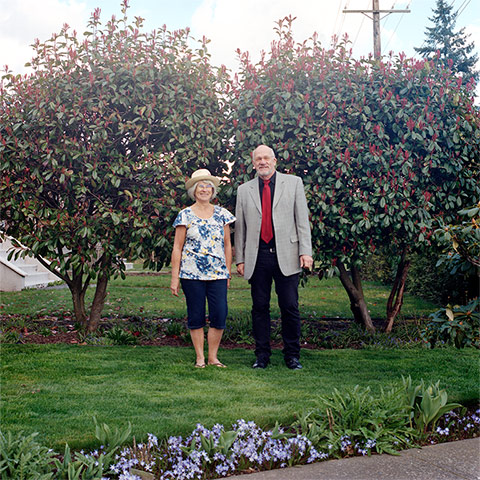 Big Picture - Hana Pesut: couple clothes swapping hana pesut switcheroo woman wearing floral shirt and cropped trousers man wearing grey jacket red tie and black trousers