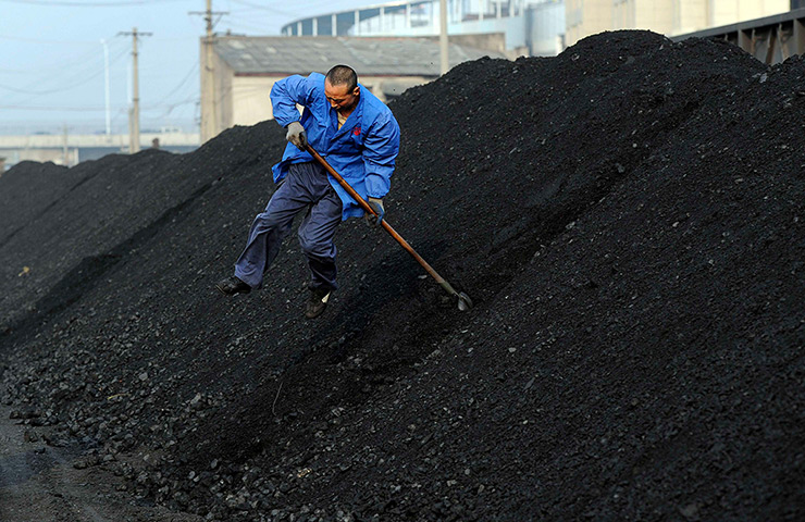 24 hours in pictures: A worker shovels coal at a freight yard in Hefei