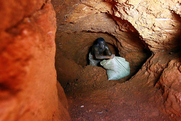 24 hours in pictures: A gold miner carries a bag of sandy soil 