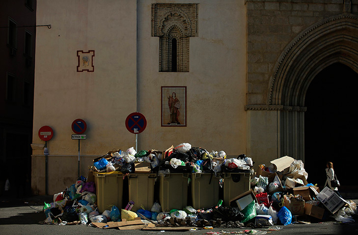 24 hours in pictures: A woman walks past a pile of trash during the ninth day of strike