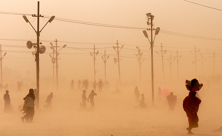 24 hours in pictures: Indian Hindu devotees walk through a dust storm