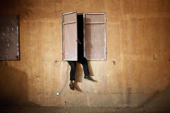 24 hours in pictures: A Malian man sits on a window sill