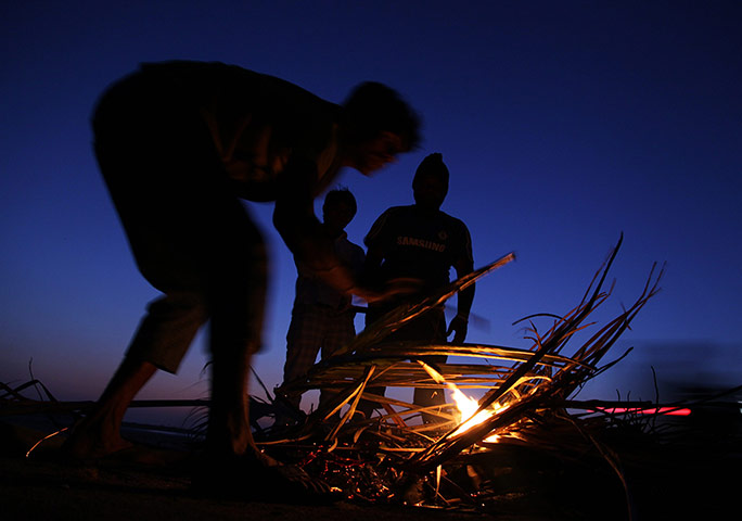 24 Hours: Mumbai, India: Men start a small bonfire along the Arabian Sea coast