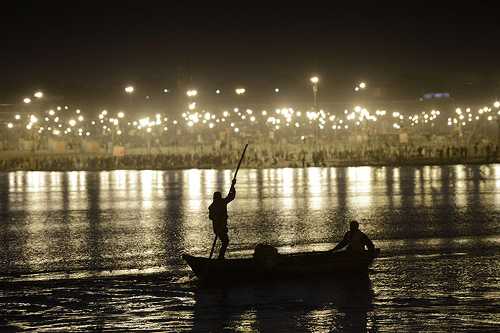 24 Hours: Allahabad, India: Two men use a boat to make their way up the Ganges